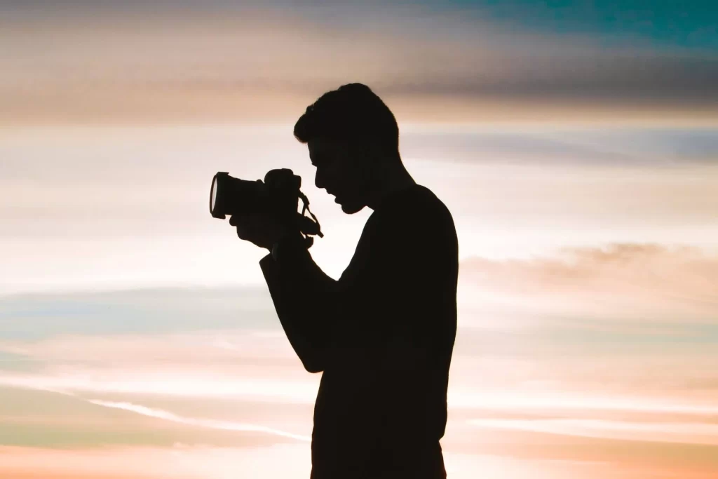 a-shadow-of-a-boy-carrying-the-camera-with-red-sky-behind